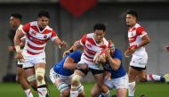 Japan's winger Kenki Fukuoka (C) is tackled during the rugby union Test match between Japan and Italy at Noevir Stadium in Kobe on June 16, 2018. / AFP / Martin BUREAU