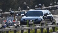 The car believed to be carrying North Korean leader Kim Jong Un is escorted by motorcycles in Beijing on June 19, 2018. / AFP / GREG BAKER 
