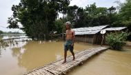 A man uses a makeshift bamboo bridge to cross a flooded area at a village in Nagaon district, in the northeastern state of Assam, India, June 19, 2018. REUTERS/Anuwar Hazarika