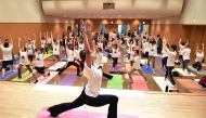 Yoga practitioners attend a special yoga session to mark International Yoga Day at Tokyo's Zojoji Temple on June 21, 2018. AFP / Kazuhiro NOGI