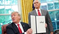 Watched by Vice President Mike Pence, US President Donald Trump shows an executive order on immigration which he just signed in the Oval Office of the White House on June 20, 2018 in Washington, DC.   AFP / Mandel Ngan
