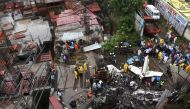 Indian rescue workers, firemen and investigators gather around the wreckage of a small plane that crashed into a construction site, killing five people, in Mumbai on June 28, 2018.