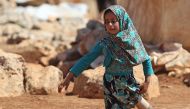 In this file photo taken on June 20, 2018 Eight year-old Maya Mohammad Ali Merhi walks using prosthetic legs made by her father from tin cans in a camp for displaced people, in the northern Syrian province of Idlib. (AFP / Aaref WATAD)