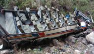 This handout photo taken and released on July 1, 2018 by the State Disater Response Found (SDRF), shows a wrecked bus and passengers belongings scattered after the bus fell into a gorge in the hilly Pauri Garhwal district in the northen state of Uttarakha