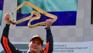 Winner Red Bull's Dutch driver Max Verstappen celebrates on the podium with the trophy after winning the Austrian Formula One Grand Prix in Spielberg, central Austria, on July 1, 2018. / AFP / ANDREJ ISAKOVIC