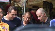 Two British divers John Volanthen (L) and Richard William Stanton (R) are seen with Thai rescue personnel at the Tham Luang cave area at Khun Nam Nang Non Forest Park in the Mae Sai district of Chiang Rai province on July 3, 2018 after finding the childre