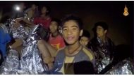 Boys from the under-16 soccer team trapped inside Tham Luang cave covered in hypothermia blankets react to the camera in Chiang Rai, Thailand, in this still image taken from a July 3, 2018 video by Thai Navy Seal. (Thai Navy Seal/Handout via REUTERS TV)