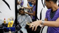 A man gets a haircut after paying for it with two packages of corn flour in Caracas, Venezuela June 29, 2018. Reuters/Marco Bello