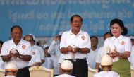 Honorary CPP president and President of the Cambodian National Assembly Heng Samrin (L), Cambodia's Prime Minister and president of the ruling Cambodian People's Party (CPP) Hun Sen (C) and his wife Bun Rany prepare to release doves as they attend an elec