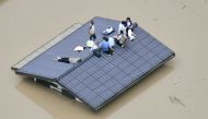 An aerial view shows local residents seen on the roof of submerged house at a flooded area as they wait for a rescue in Kurashiki, southern Japan, in this photo taken by Kyodo July 7, 2018. Mandatory credit Kyodo/via REUTERS