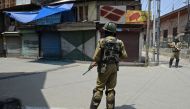 Indian paramilitary troopers stands guard in front of closed shops during a one-day strike in Srinagar on July 7, 2018. AFP / TAUSEEF MUSTAFA