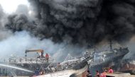 Indonesia worker and firefighters try to extinguish a fire on fishing boats at Benoa harbour in Denpasar, on Indonesia's resort island of Bali on July 9, 2018. AFP / Sonny Tumbelaka 