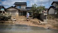 A woman removes mud from her damaged home in a flood hit area in Mabi, Okayama prefecture on July 10, 2018. AFP / Martin BUREAU
