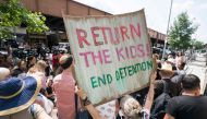 Protesters hold signs as Ravi Ragbir, of the New Sanctuary Coalition, speaks at a press conference to spotlight the impact of the government’s stalling tactics immigrant families on July 11, 2018 in New York.  AFP / Don Emmert  