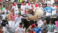 Runners sprint in front of the bulls during the last running of the bulls at the San Fermin festival in Pamplona, Spain, July 14, 2018. REUTERS/Susana Vera