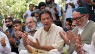 Imran Khan (C), chairman of the Pakistan Tehreek-e-Insaf (PTI), holds his palms to pray and expresses condolence to the relatives of deceased Siraj Raisani, provincial assembly candidate of Baluchistan Awami Party (BAP), who was killed in Friday's suicide