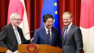 Japanese Prime Minister Shinzo Abe, center, European Commission President Jean-Claude Juncker, left, and European Council President Donald Tusk, right, smile after their joint press conference of Japan-EU summit at Abe's official residence in Tokyo, Tuesd