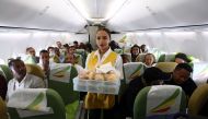 Flight attendant serves passengers with breakfast inside an Ethiopian Airlines ET314 flight to Eritrea's capital Asmara, from the Bole International Airport in Addis Ababa, Ethiopia July 18, 2018. (REUTERS/Tiksa Negeri)