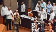 Cuba's President Miguel Diaz-Canel (2-L) applauds as former President Raul Castro (4-L) waves upon arriving to attend the National Assembly's session to present the new Council of Ministers and discuss the draft of 224 articles prepared by a parliamentary