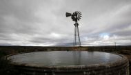 ARCHIVE PHOTO: Storm clouds loom over a borehole windmill near Carnavon in South Africa's remote and arid Northern Cape province in this picture taken May 17, 2012. Reuters/Mike Hutchings
