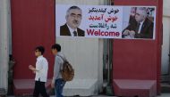 Afghan residents walk past a banner with the image of self-exiled Afghan Vice President Abdul Rashid Dostum ahead of his arrival to Kabul on July 22, 2018. (AFP / NOORULLAH SHIRZADA)