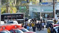Police officers and members of the Los Angeles Fire Department escort a woman on a stretcher after a suspect barricaded inside a Trader Joe's supermarket in Silverlake, Los Angeles, on July 21, 2018.  AFP / Robyn Beck

