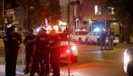 Toronto Police officers walk the scene at Danforth St. at the scene of a shooting in Toronto, Ontario, Canada on Sunday, July 23, 2018. (AFP / Cole BURSTON)