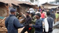 A youth is escorted by Kenyan police officers as dozens of houses are being demolished to make way for a new road in the Kibera slum in Nairobi, Kenya, July 23, 2018. Reuters/Baz Ratner