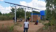 A man stands near a raised solar panel raised and reservoir tanks used for irrigation at Chiswamafupa irrigation scheme, in the traditional authority of Mambo in Zomba district, eastern Malawi, July 11, 2018. Thomson Reuters Foundation/Charles Mkoka
