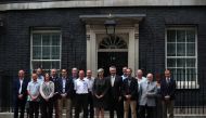 Britain's Prime Minister, Theresa May poses for a photograph with Thailand's Ambassador to the United Kingom, Pisanu Suvanajata, and the British cave divers and their suport team who helped rescue boys from a flooded cave in Thailand, in front of 10 Downi
