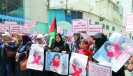 Employees of the UN Relief and Works Agency for Palestinian Refugees (UNRWA) hold UNRWA officials' photos as they gather in front of the UNRWA's headquarters in Gaza City to protest against the agency's recent decision to scale down its operations -- and 