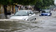 Indian commuters make their way on a flooded road following heavy rain in Mathura in India's Uttar Pradesh state on July 26, 2018. (AFP)