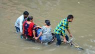 In this file photo taken on July 26, 2018 Indian women are transported on a bicycle cart on a flooded road following heavy rain in Mathura in India's Uttar Pradesh state Heavy monsoon rains that sparked floods and caused buildings to collapse. AFP