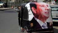 A man gestures as he rides a motorized vehicle showing a poster of Egyptian President Abdel Fattah al-Sisi during the second day of the presidential election in Cairo, Egypt, March 27, 2018. Reuters/Ammar Awad