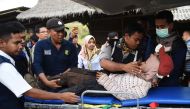 Rescue team members give treatment to a climber after walking down from Rinjani Mountain at Sembalun village in Lombok Timur, Indonesia, July 30, 2018. Antara Foto/Akbar Nugroho Gumay/via Reuters