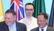 US Secretary of State Mike Pompeo (L) and North Korea's Foreign Minister Ri Yong Ho (R) smile as Philippine Foreign Secretary Alan Peter Cayetano (behind) looks on, as they arrive for a group photo at the ASEAN Regional Forum Retreat during the 51st Assoc