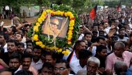Dravida Munnetra Kazhagam (DMK) party supporters display a portrait of party president Muthuvel Karunanidhi as they gather to pay respects to his remains at Rajaji hall in Chennai on August 8, 2018. AFP / Arun Sankar
 