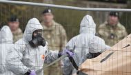 British military personnel wearing protective coveralls work to remove a vehicle connected to the March 4 nerve agent attack in Salisbury from a residential street in Gillingham on March 14, 2018. (AFP / Adrian Dennis) 