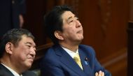 In this file photo taken on July 16, 2015 Japan's Prime Minister Shinzo Abe (R) and then Regional Revitalization Minister Shigeru Ishiba (L) listen to a speech by a member of an opposition party at the parliament in Tokyo. / AFP / Kazuhiro NOGI 