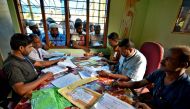 People wait to check their names on the draft list at the National Register of Citizens centre at a village in Nagaon district, Assam state, India, July 30, 2018 (Reuters) 