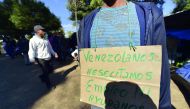 A man with a sign hanging that reads 