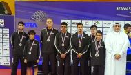 Qatar’s table tennis team players and officials pose for a group picture.