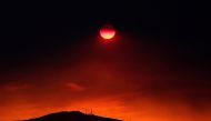 The sun sets under a cloud of smoke caused by a wildfire fanned by strong winds on the island of Evia, in Athens, Greece, August 12, 2018. Reuters/Yannis Behrakis