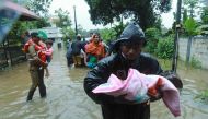 Fire and Rescue personnel evacuate local residents in an inflatable boat from a flooded area at Muppathadam near Eloor in Kochi's Ernakulam district, in the Indian state of Kerala on August 15, 2018. / AFP / - 
