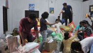 Volunteering members of the public help sort flood relief material at the District Tourism Promotion Council (DTPC), in Kozhikode district, about 385 km north of Trivandrum, in the south Indian state of Kerala, on August 17, 2018.  AFP / Manjunath Kiran