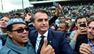 Brazilian presidential candidate for the Social Liberal Party (PSL) Jair Bolsonaro (C) poses for a picture with a military woman during the graduation ceremony of a military school in Sao Paulo, Brazil on August 17, 2018. Brazilian general elections will 