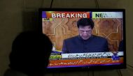 A man looks at a television screen displaying cricketer-turned-politician Imran Khan swearing in as Prime Minister of Pakistan, in Karachi, Pakistan August 18, 2018. REUTERS/Akhtar Soomro