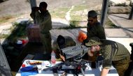 Israeli soldiers looks through binoculars at an observation post near the Israeli side of the Israel - GAZA border, Israel August 15, 2018. REUTERS/Amir Cohen 