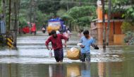 Indian men carry food and water aid distributed to those stranded by floods in Pandanad in Alappuzha District in the south Indian state of Kerala on August 21, 2018. (AFP / MANJUNATH KIRAN)