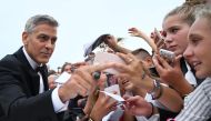 US actor and director George Clooney signs autographs before the premiere of the movie 